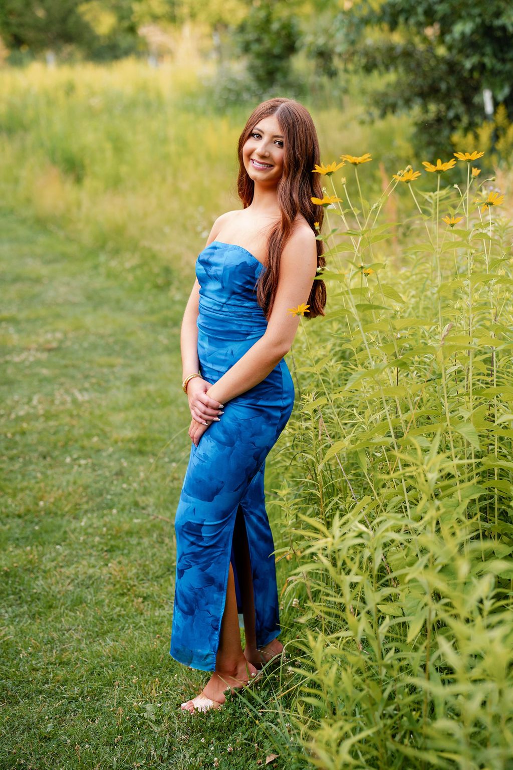 Outdoor photoshoot in a meadow with yellow wildflowers and blue clothing.