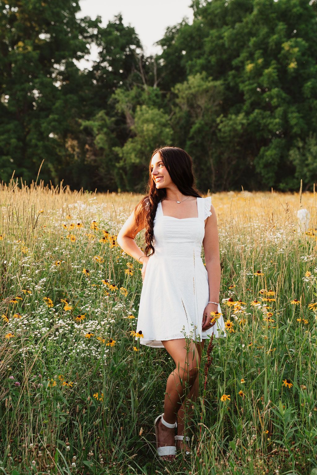 White summer dress twirling through a meadow of wildflowers at golden hour.