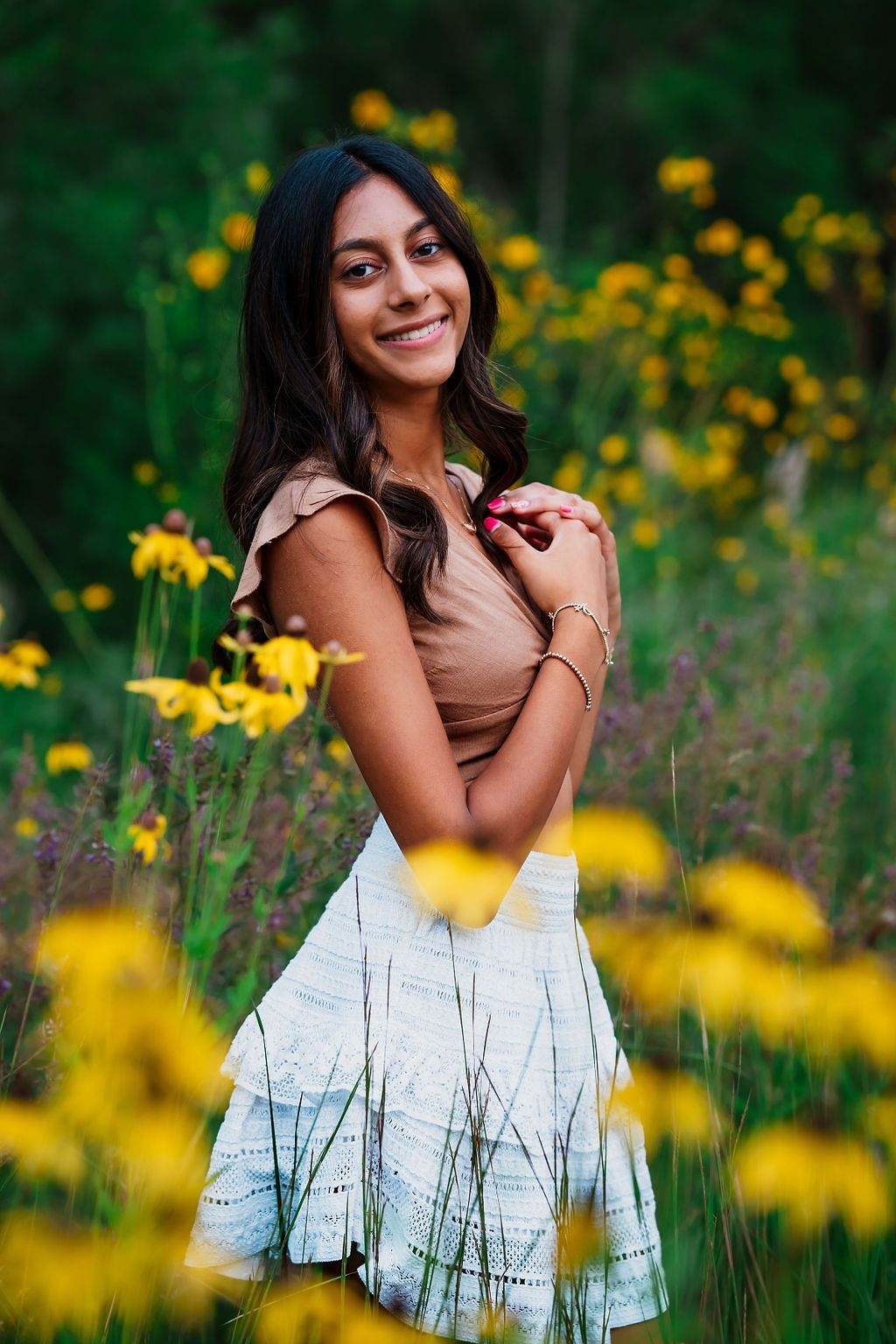 Portrait session in a field of vibrant yellow wildflowers with a white dress creating a dreamy summer atmosphere.