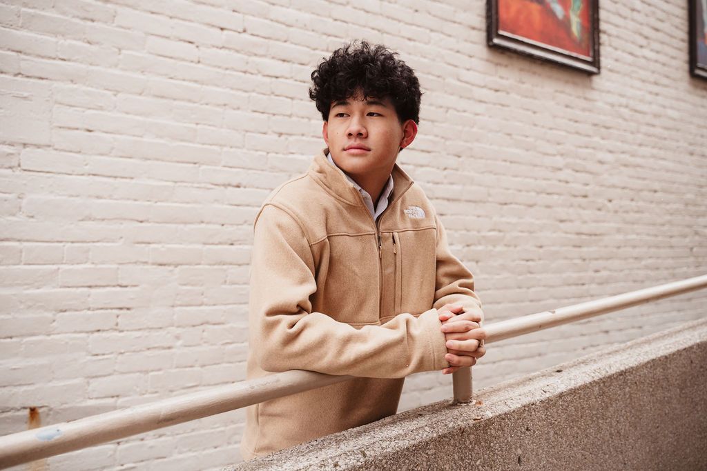 Urban portrait session against white painted brick wall in natural lighting.