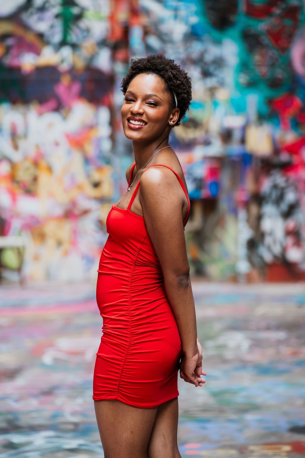 A person in a red swimsuit poses confidently against a vibrant graffiti wall background in multiple artistic shots.