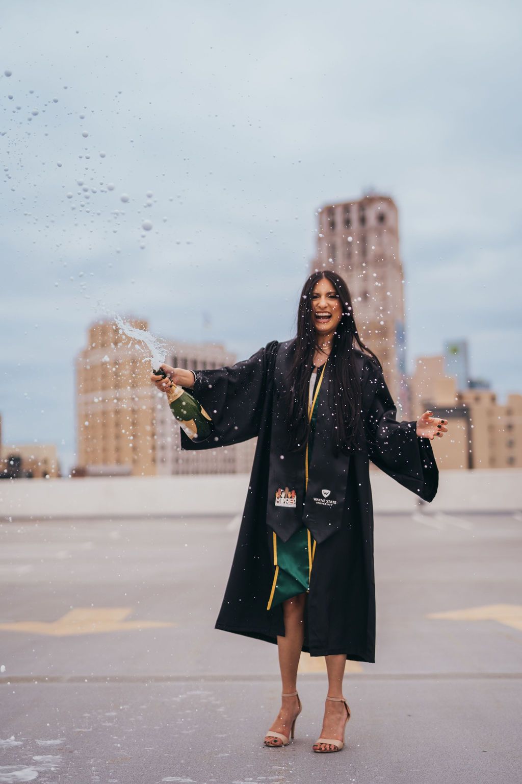 A person in a black coat poses against an urban backdrop with tall buildings in a sequence of dynamic movements.