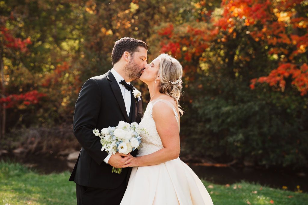Fall wedding portraits with vibrant autumn foliage in background.