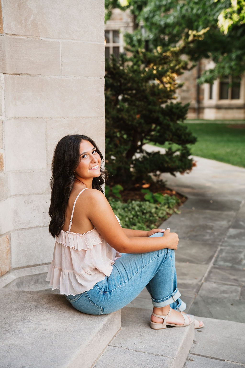 Casual portrait session on stone steps with architectural backdrop.