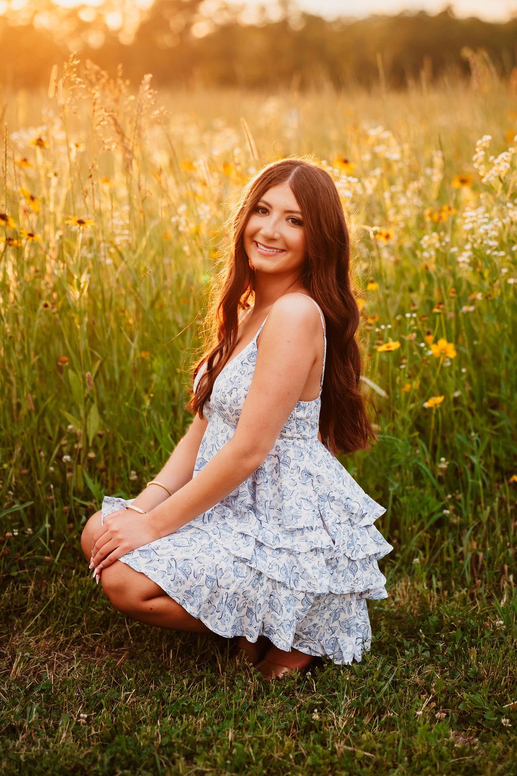 A summer portrait session in a sun-drenched field with blooming wildflowers and warm evening light.