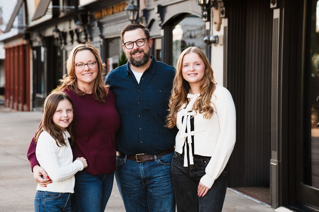 Stylish family portrait session against modern downtown architecture and storefronts.
