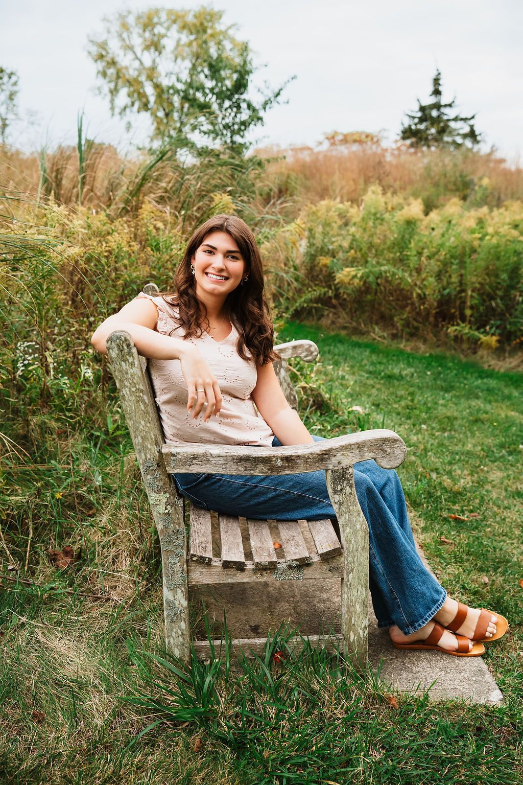 Rustic wooden bench portrait session in a grassy field during golden hour.