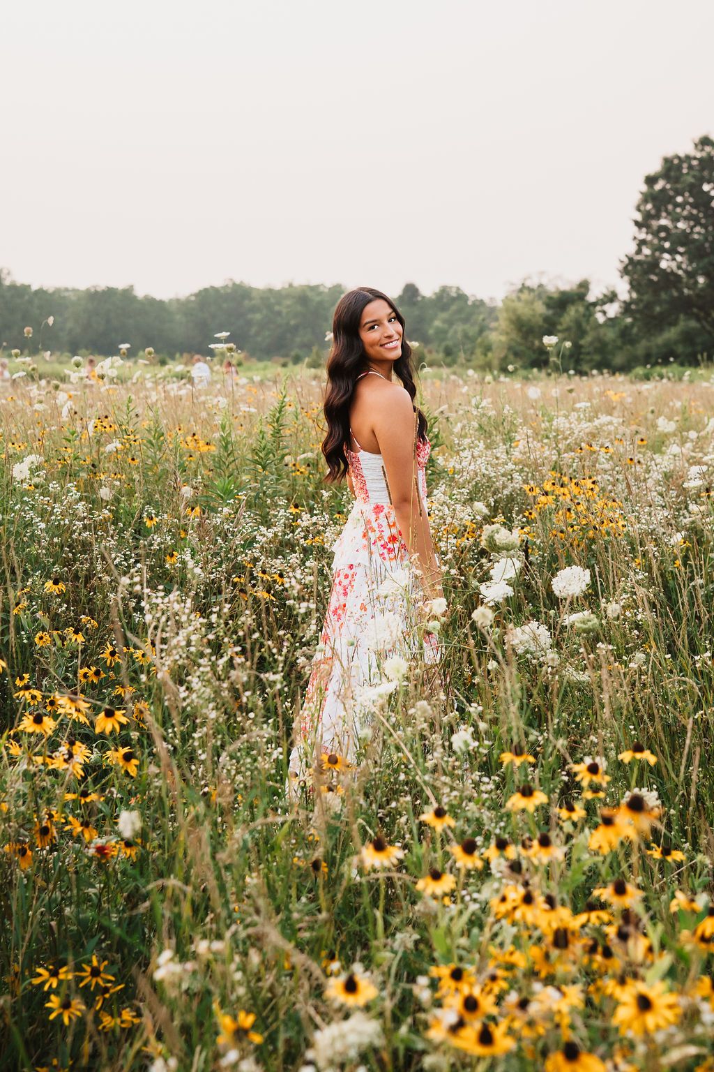 A floral sundress stands out among vibrant yellow wildflowers and white daisies in a summer meadow.