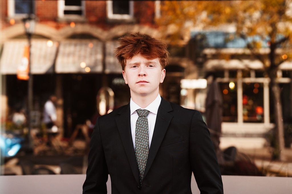 Professional portrait in business attire against an urban autumn backdrop. Northville, Michigan. PCEP Senior Photos