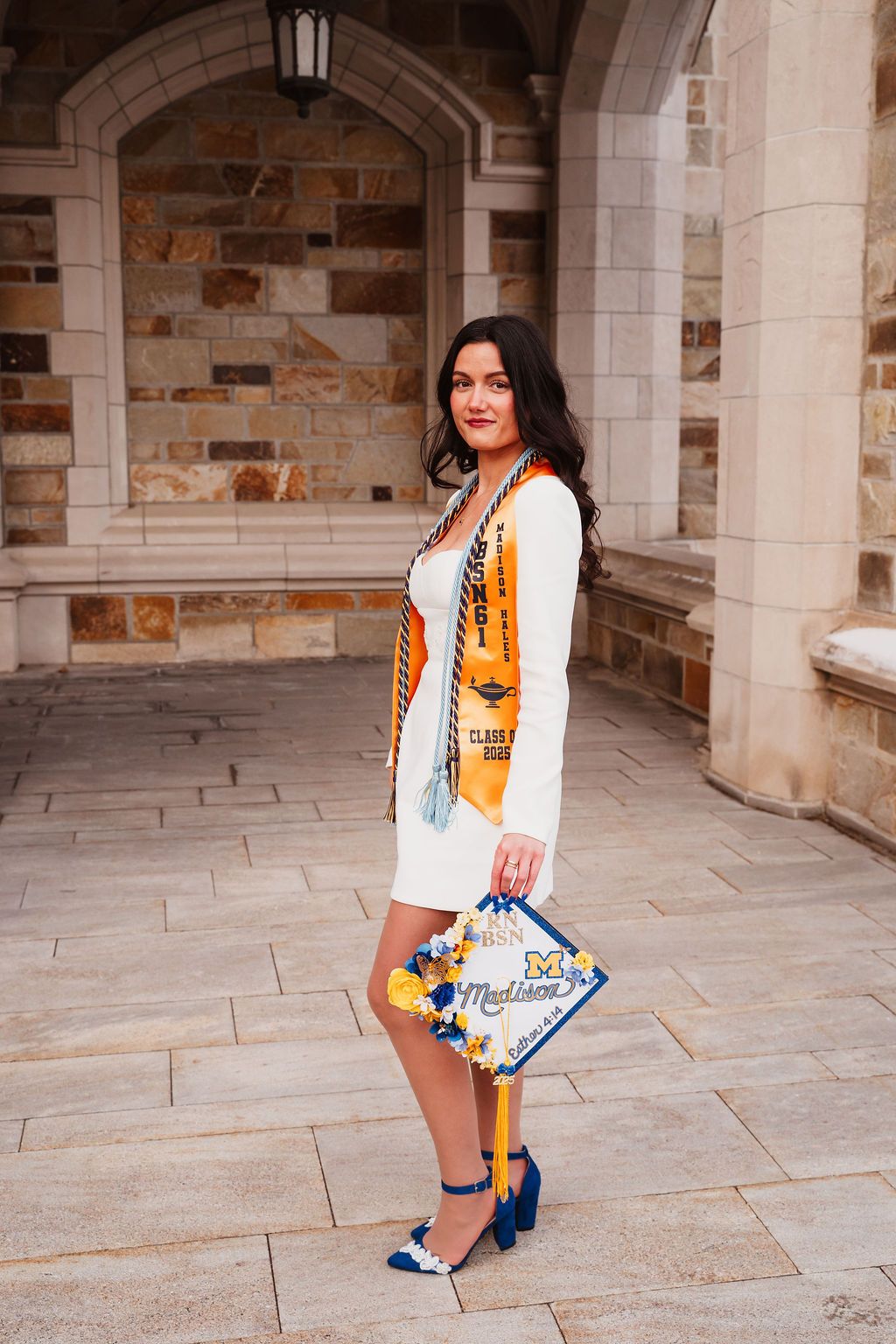 Fashion portrait series showing woman in white and orange outfit posing against stone archway.