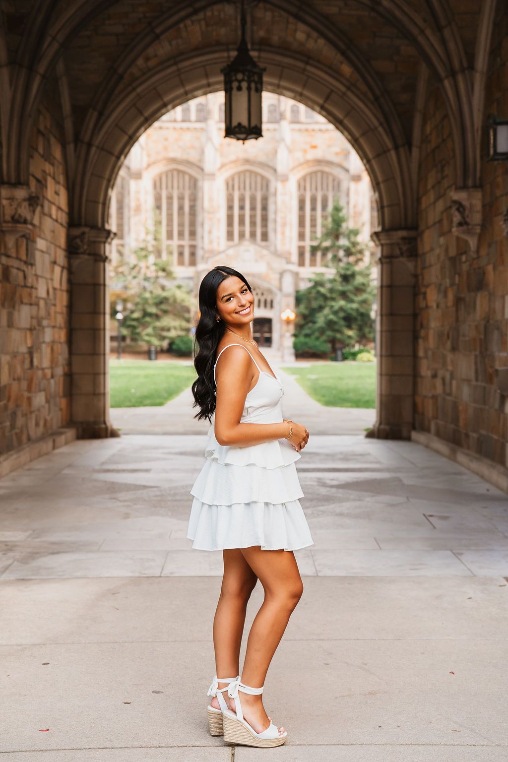 Stone archways frame an elegant summer photoshoot in a collegiate gothic setting.
