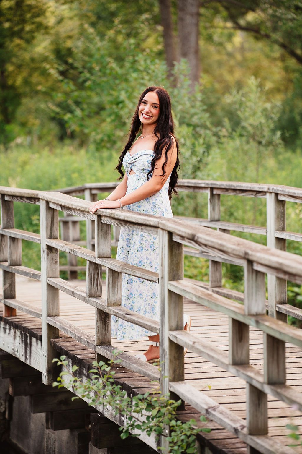 Wooden footbridge winding through a serene natural setting.