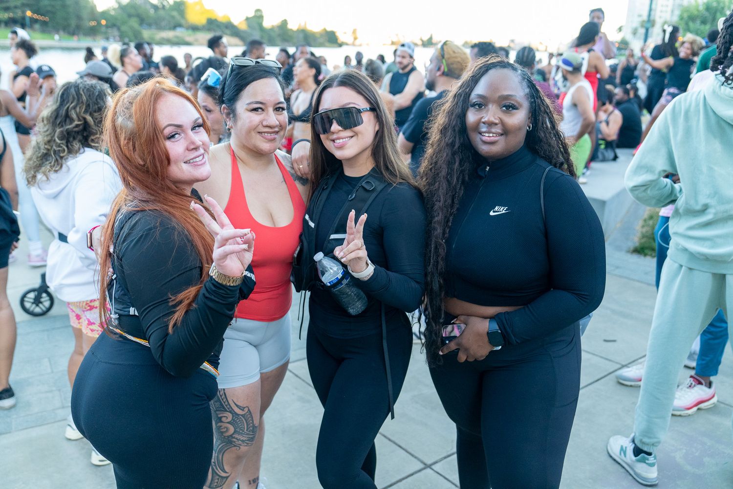 Group of friends gathering outdoors at a waterfront fitness event.