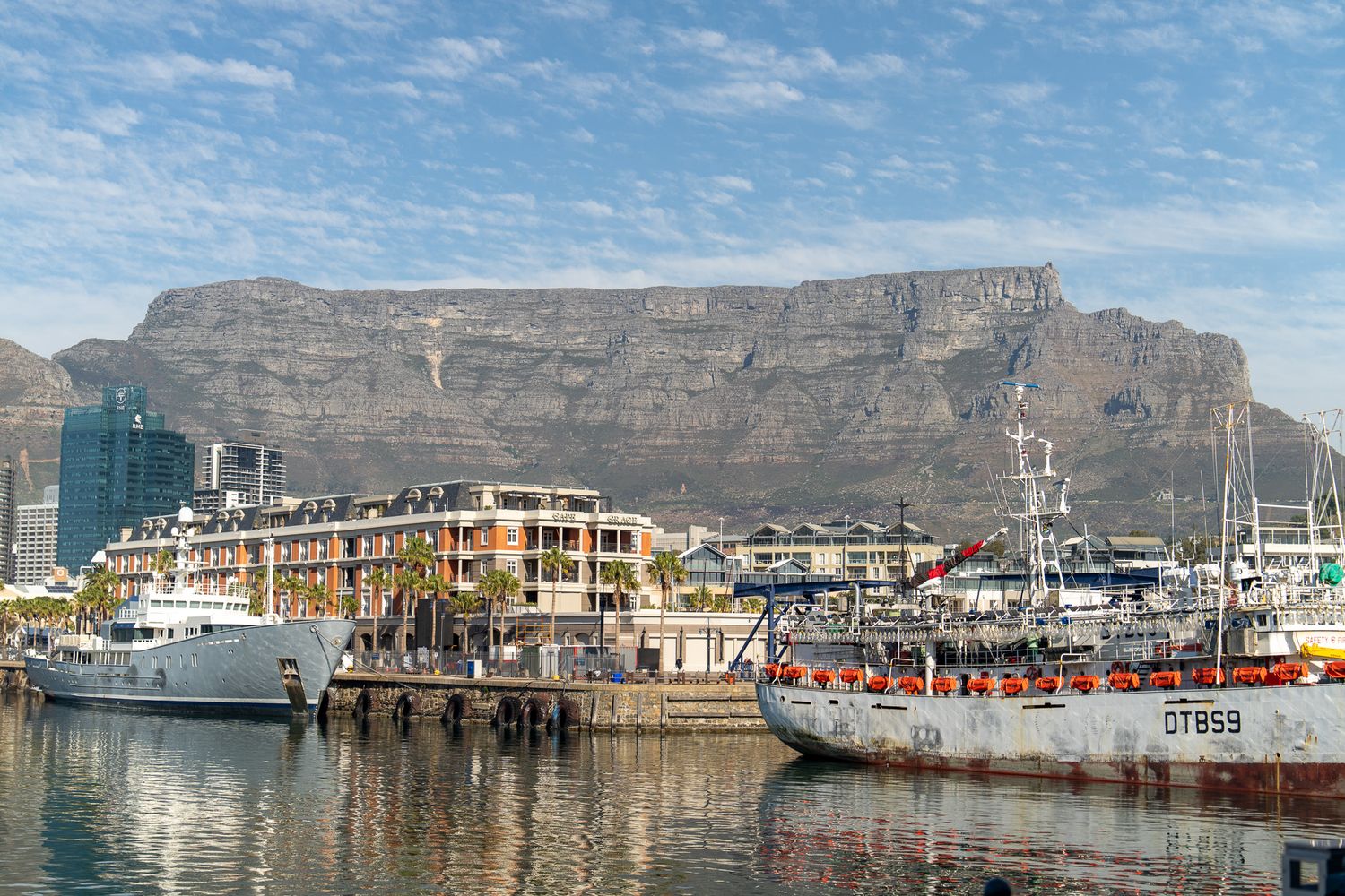 Panoramic view of Cape Town's waterfront with Table Mountain as a dramatic backdrop.