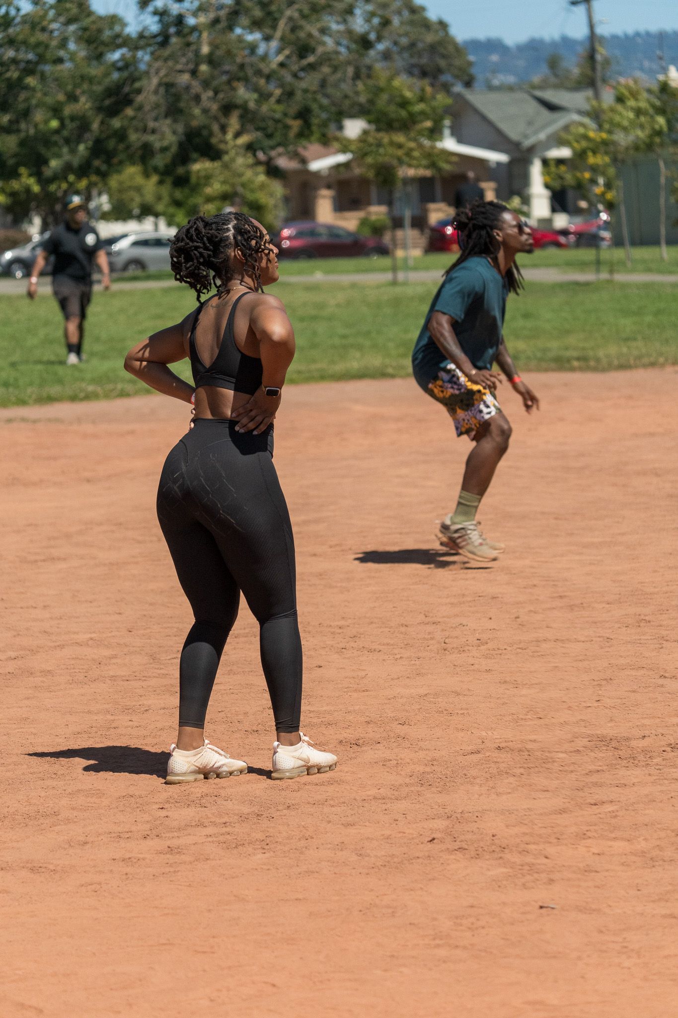 Sports players positioned on a dirt field during a game or practice session.