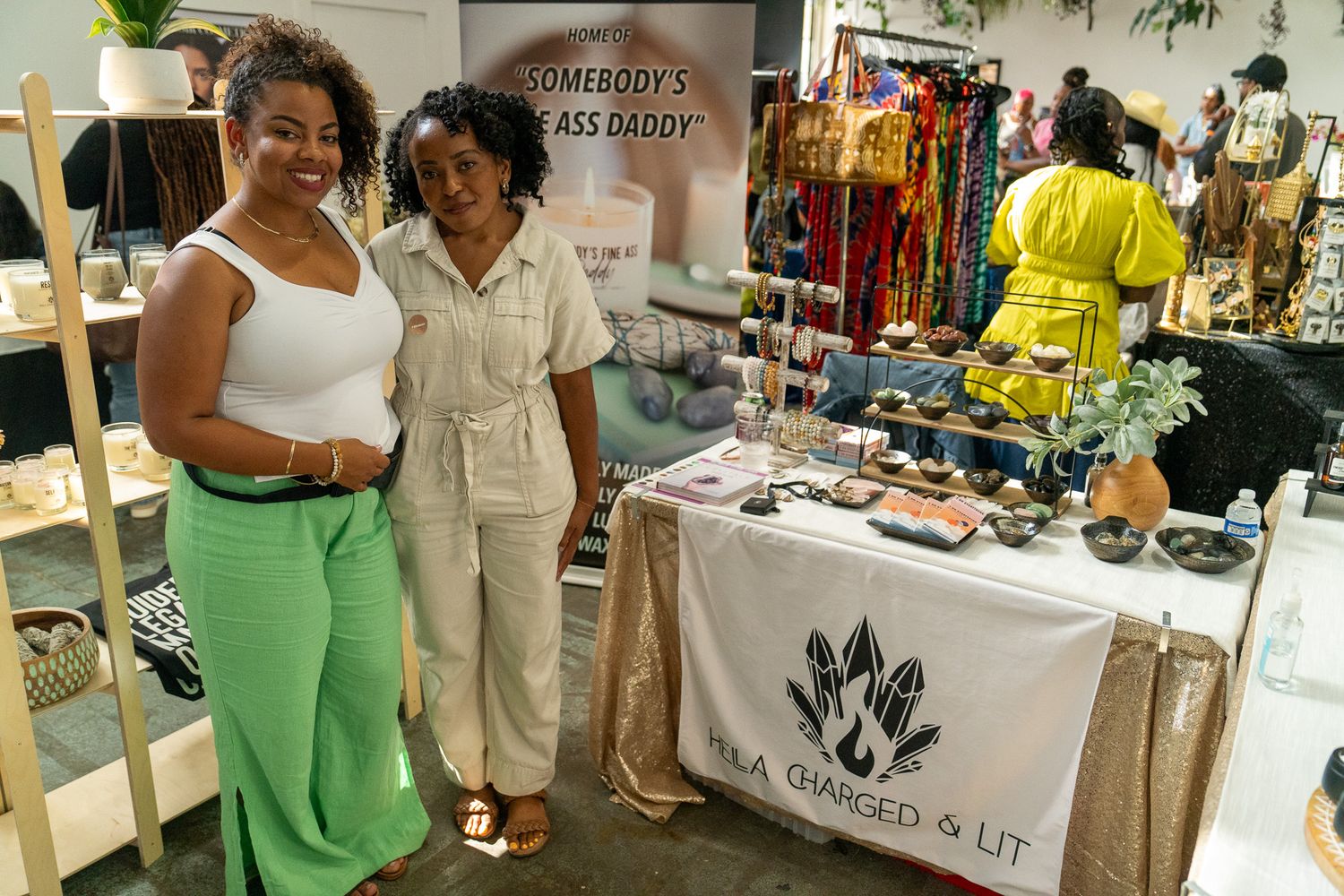 Vendors showcase their products at stalls during an indoor marketplace.