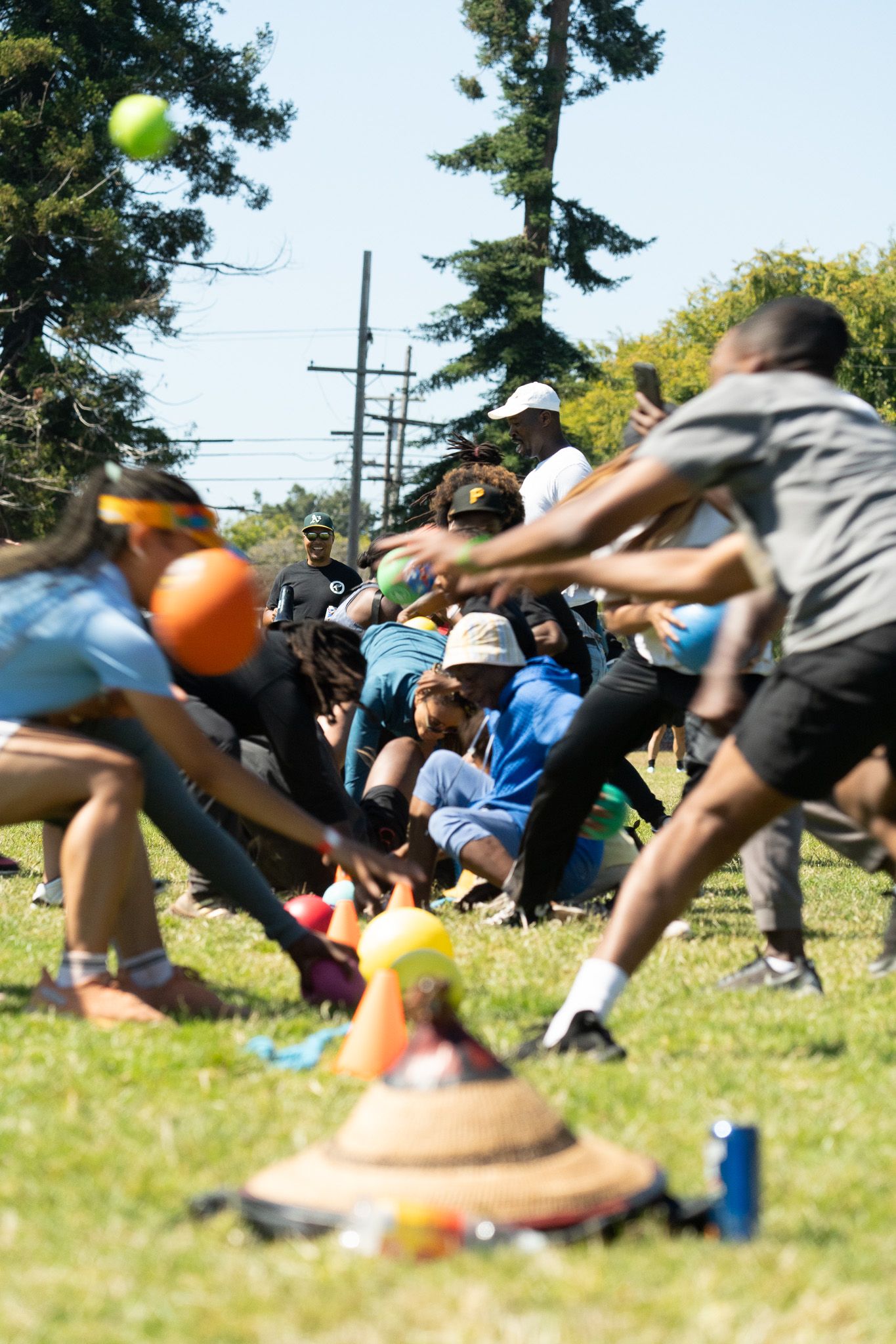 Athletes performing dodgeball drills on a sunny grass field.