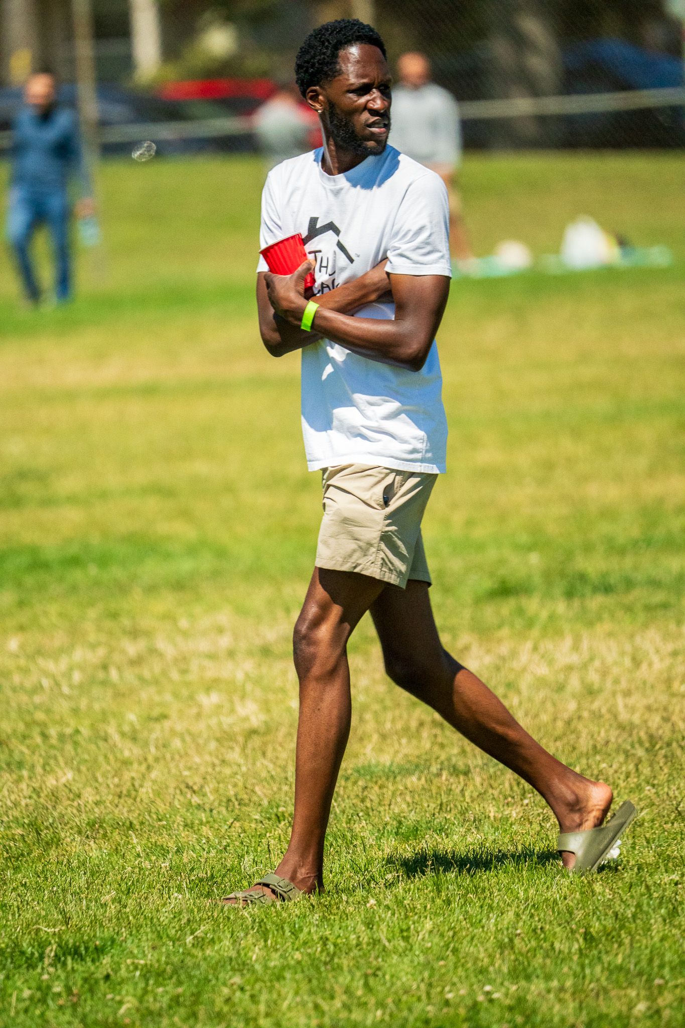 Athletes practicing throwing motions on a sunny grass field during outdoor training.