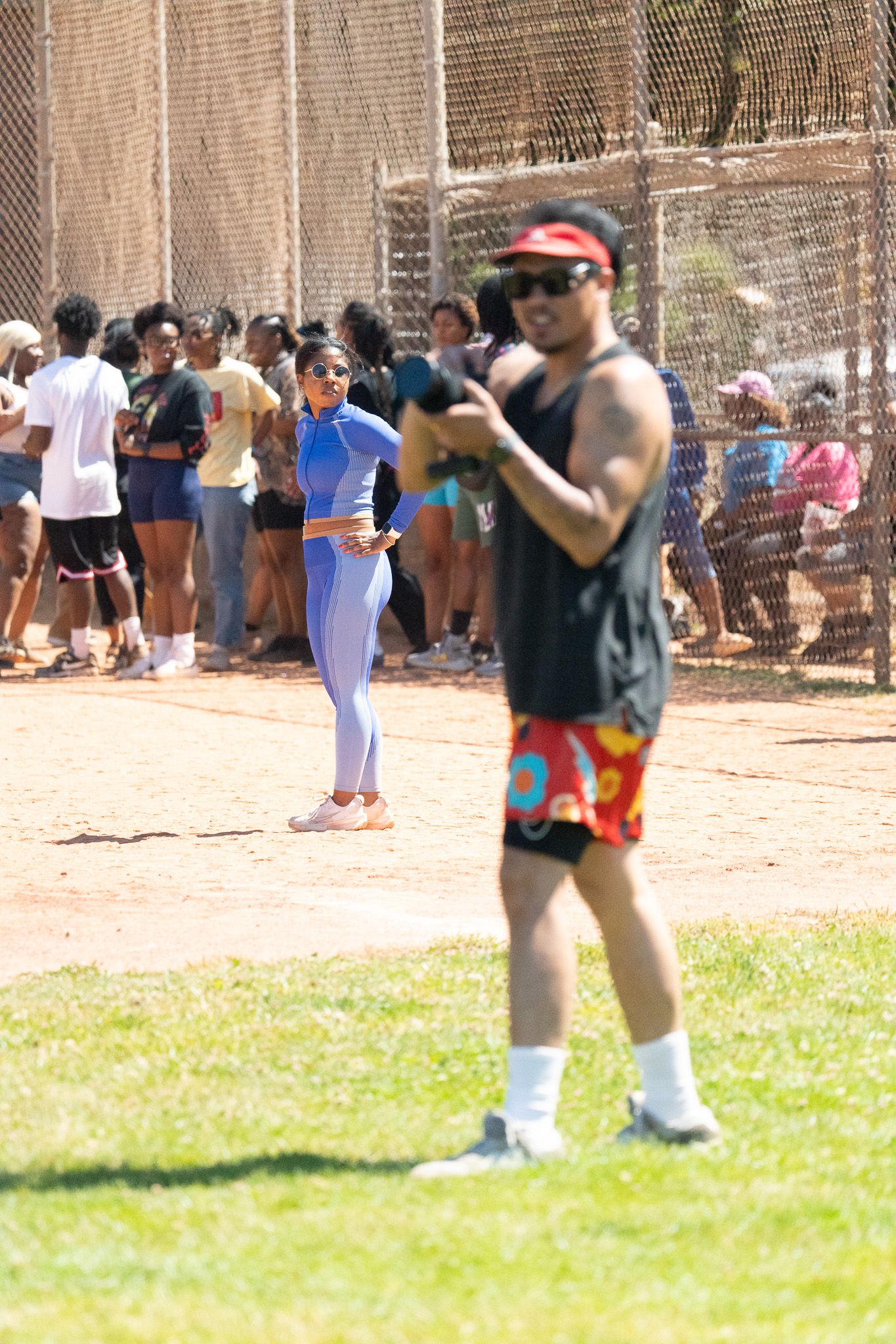 People scattered across a dirt and grass field during an outdoor event.