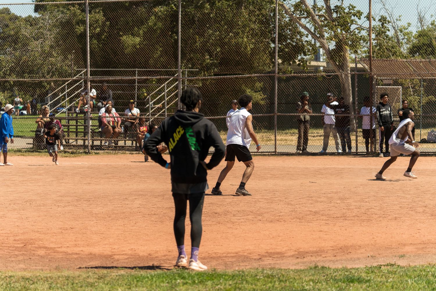 Athletes playing a recreational sport on a dusty outdoor field.