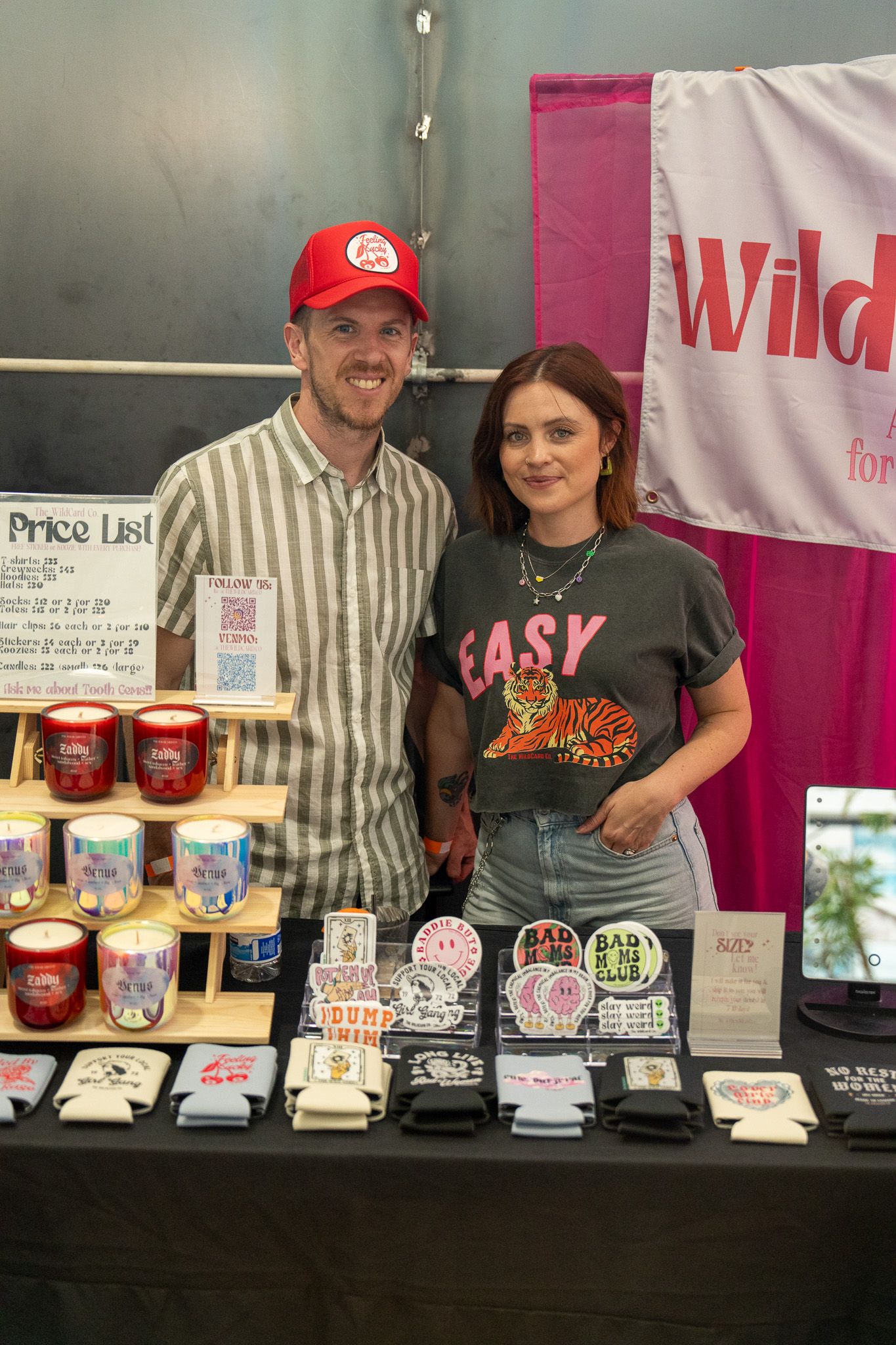 Vendor table displays various candles and products with price list signage.