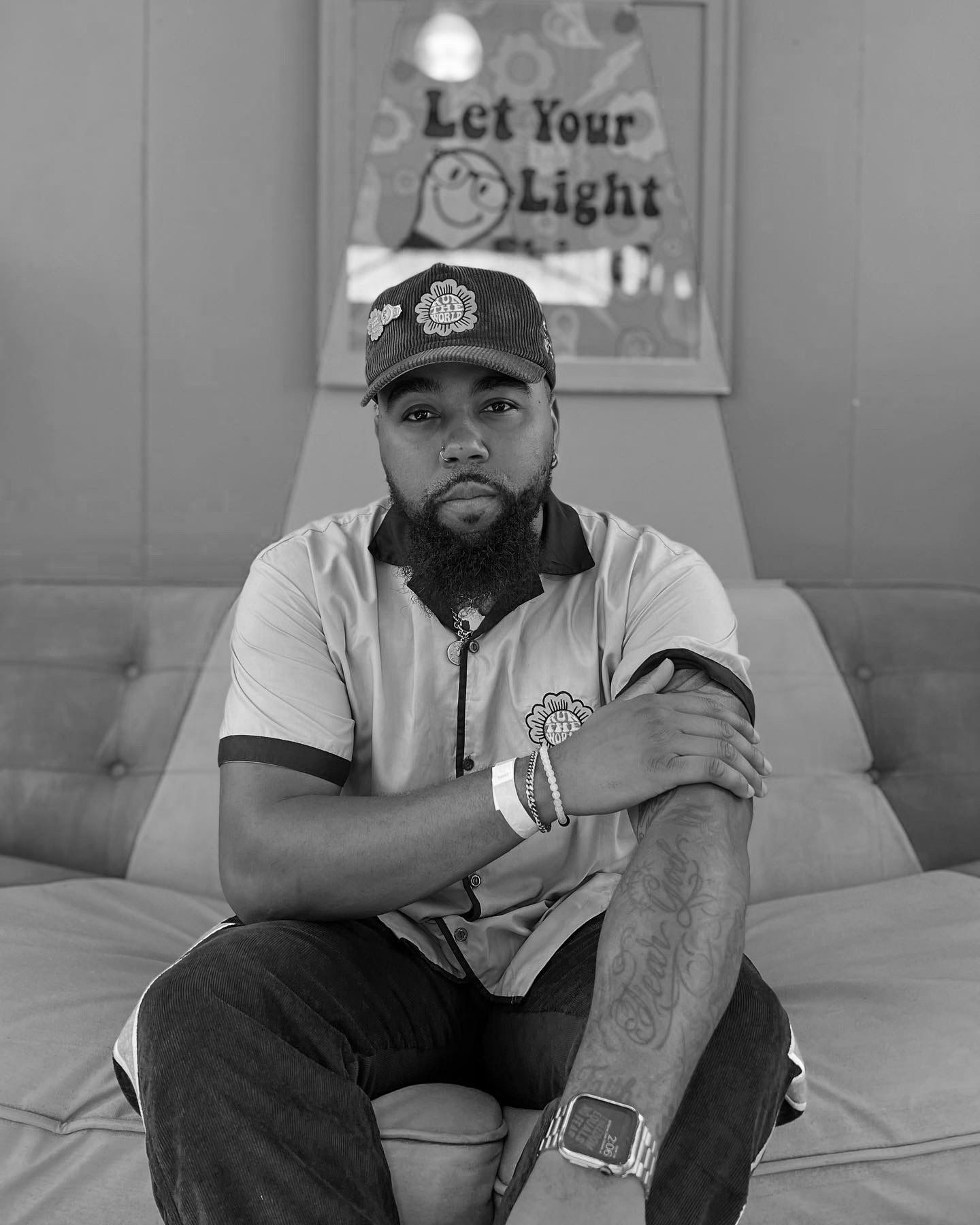 Black and white portrait of someone sitting thoughtfully on a couch.