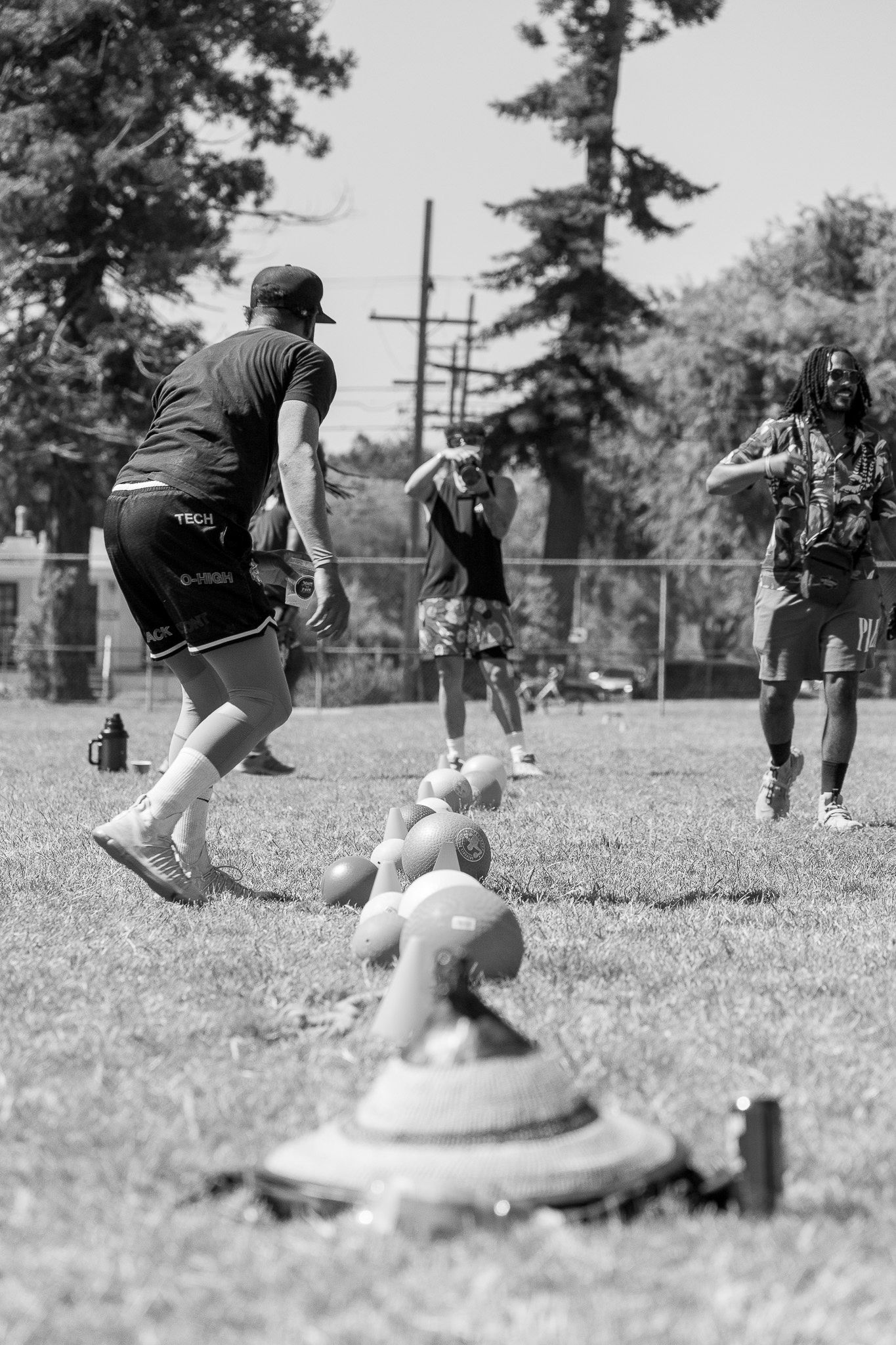 Sequence of black and white photos showing a dog jumping and performing fetch exercises on a grassy field.