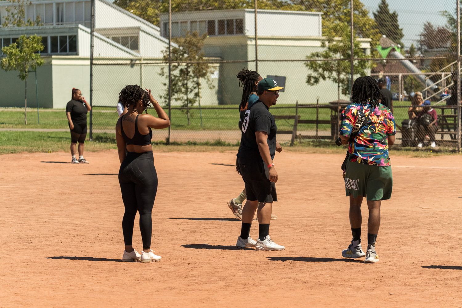 Players spread out across a dirt field during an outdoor sports game.