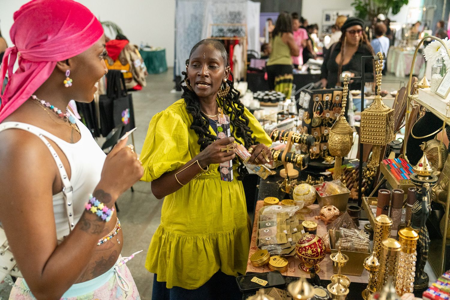 Attendees browse vendor displays at a vibrant indoor market event.