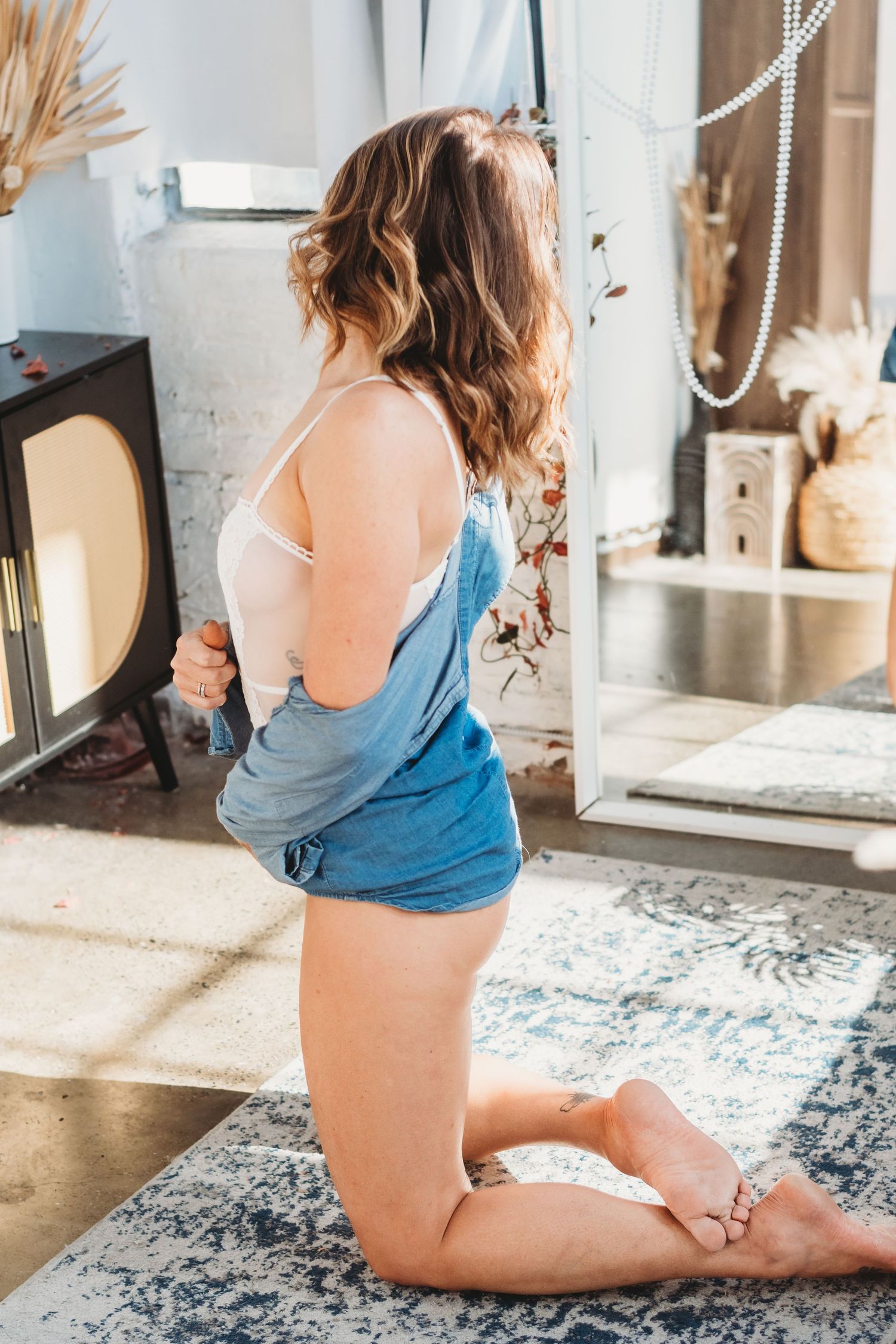 Charleston, Lowcountry Bride admiring her confidence growing in the mirror during her bridal boudoir session in the studio