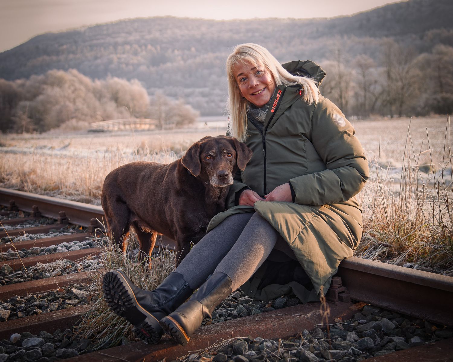Eine Outdoor-Lifestyle-Fotos, die Besitzerin und Ihr Hund sitzend auf rostigen Bahngleisen in Gasseldorf - Streitberg - Behringersmühle