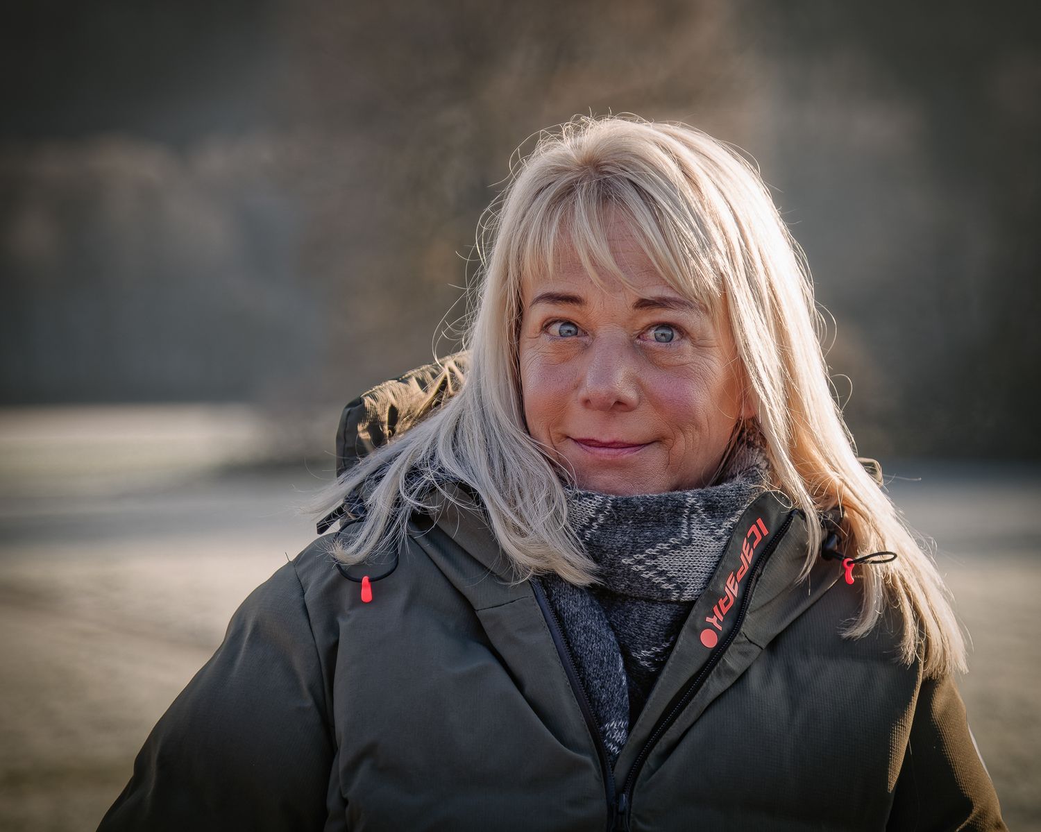 Person mit blonden Haaren und Wintermantel in eine Nahaufnahmen von Outdoor-Porträts mit natürlicher Beleuchtung.