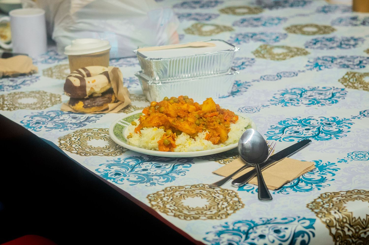 Table set with colorful tablecloth and bright orange food dishes.