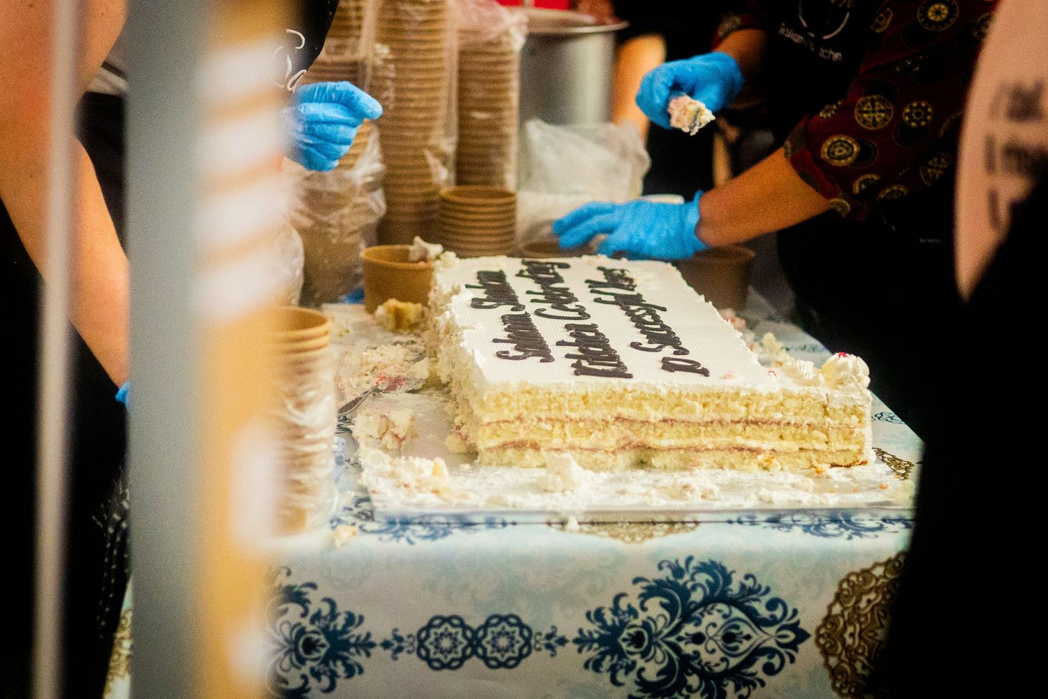 Decorative cake with ornate blue patterns being displayed at an event.