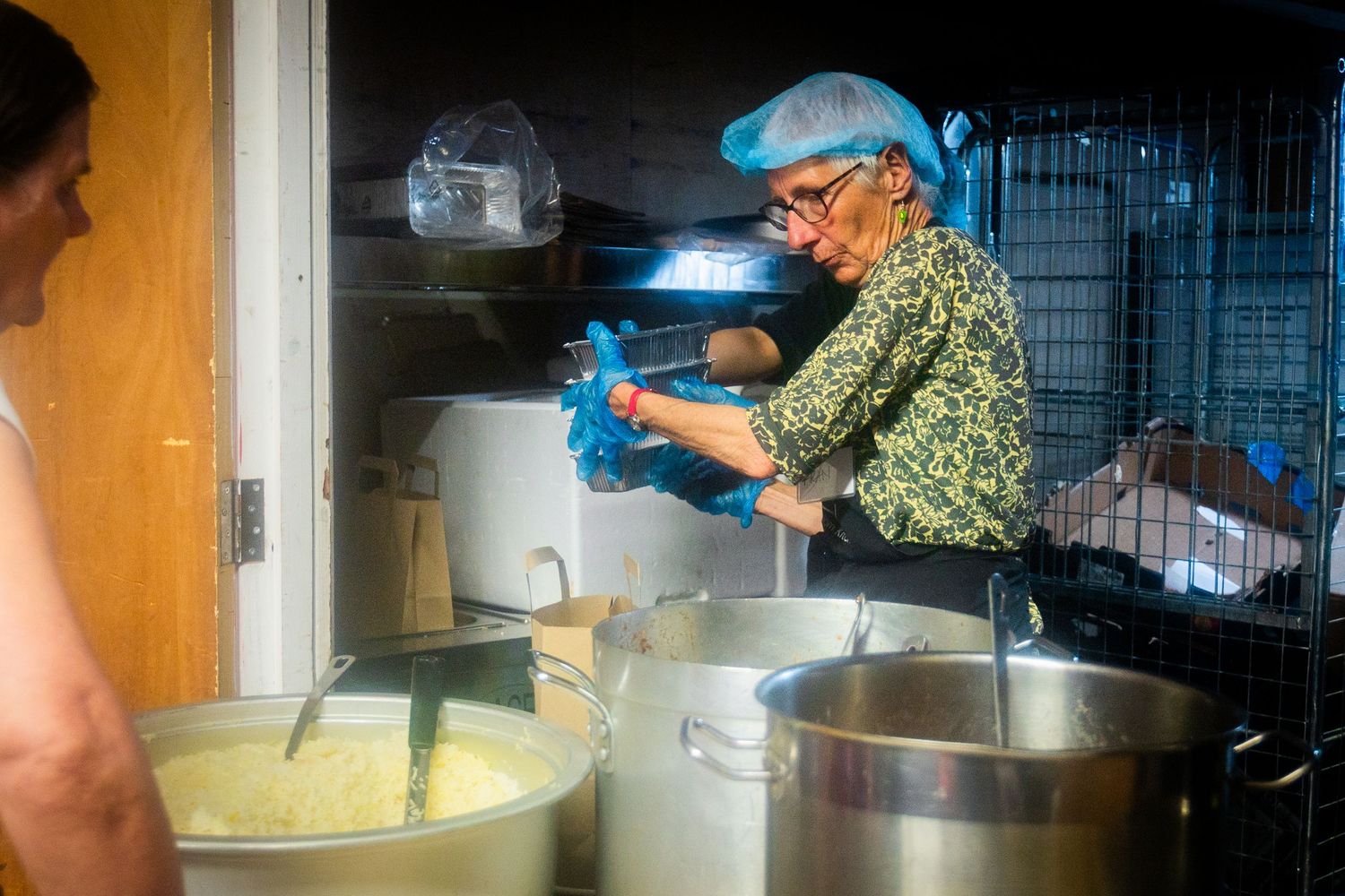 Commercial kitchen scene showing food preparation with mixing bowls and cooking equipment.