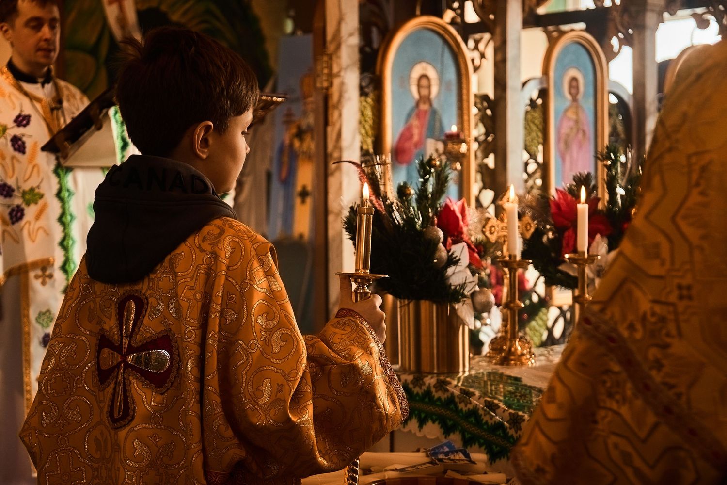 Church interior with traditional religious artwork and icons displayed along decorative wooden walls.