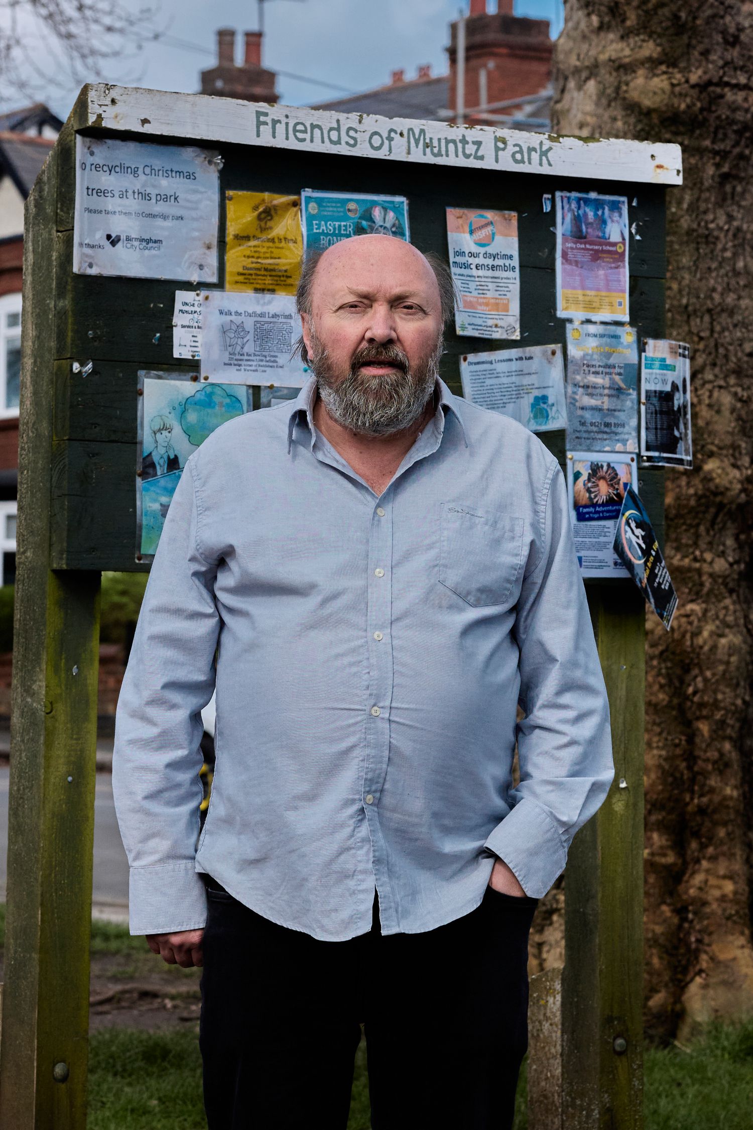 A person stands in front of a community bulletin board displaying 