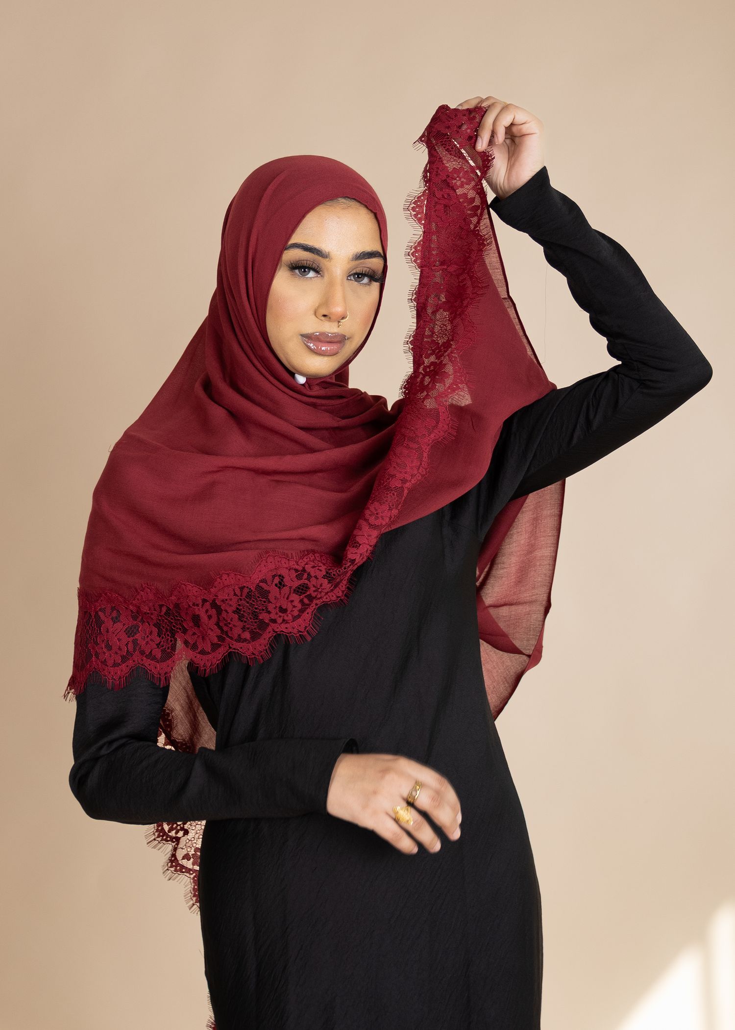 A sequence of photos showing a burgundy hijab with delicate lace trim being styled in different elegant poses.
