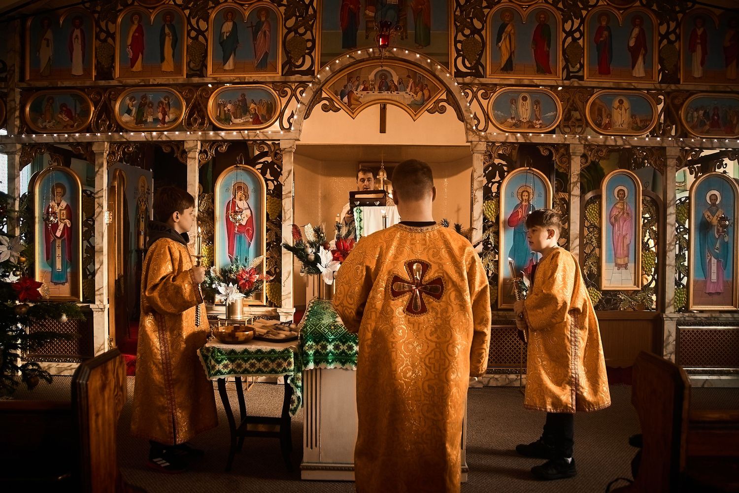 Panoramic view of an Orthodox church interior with ornate iconostasis and golden details.