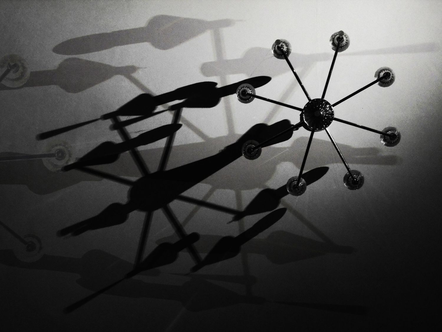 A group of figures in superhero costumes strike dramatic silhouetted flying poses against a cloudy sky.