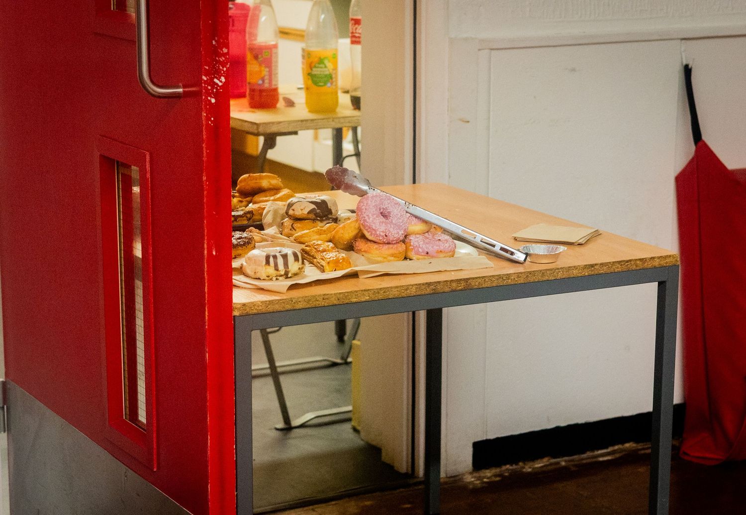Red metal storage shelves holding various kitchen supplies and equipment in an organized space.