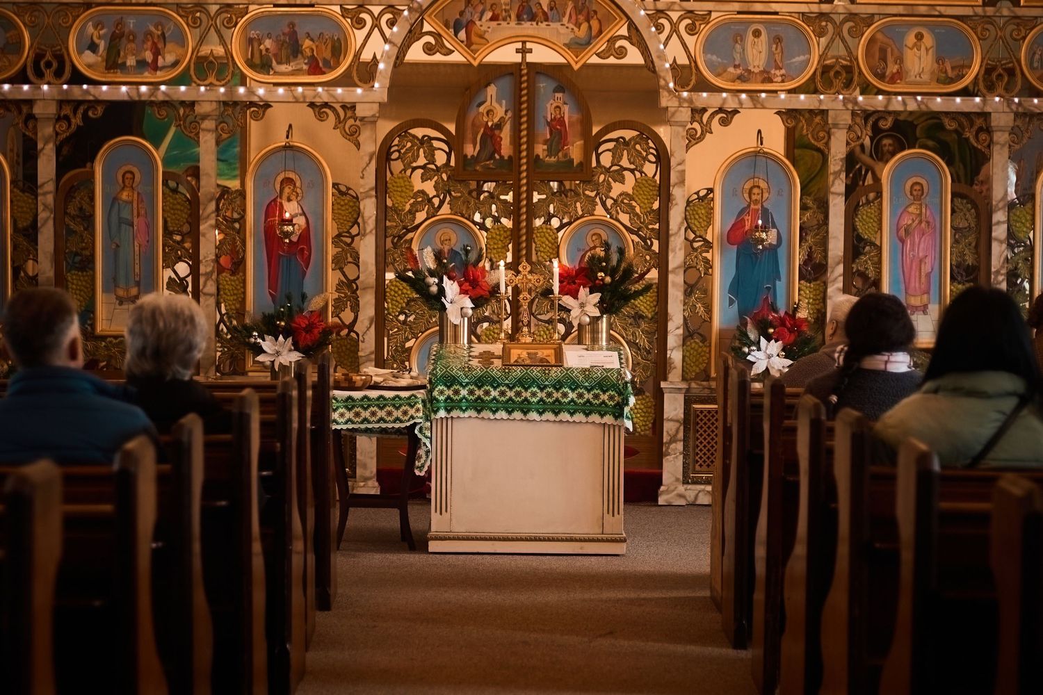 Beautiful Orthodox church interior with ornate iconostasis and empty wooden pews.