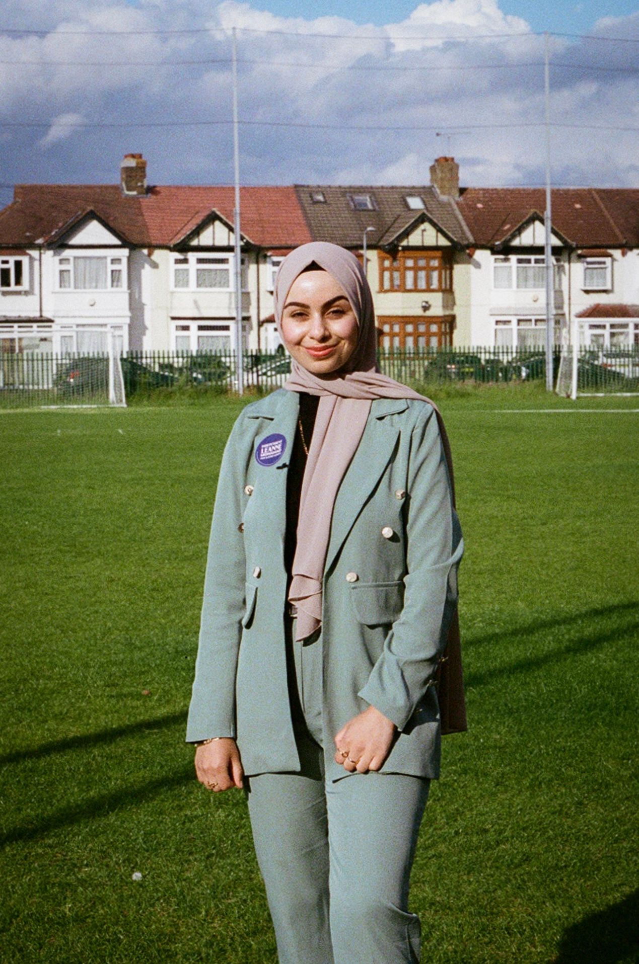 Leanne Mohamad poses on the grass with suburban houses in background in Ilford during campaigning as an independant in the general election.