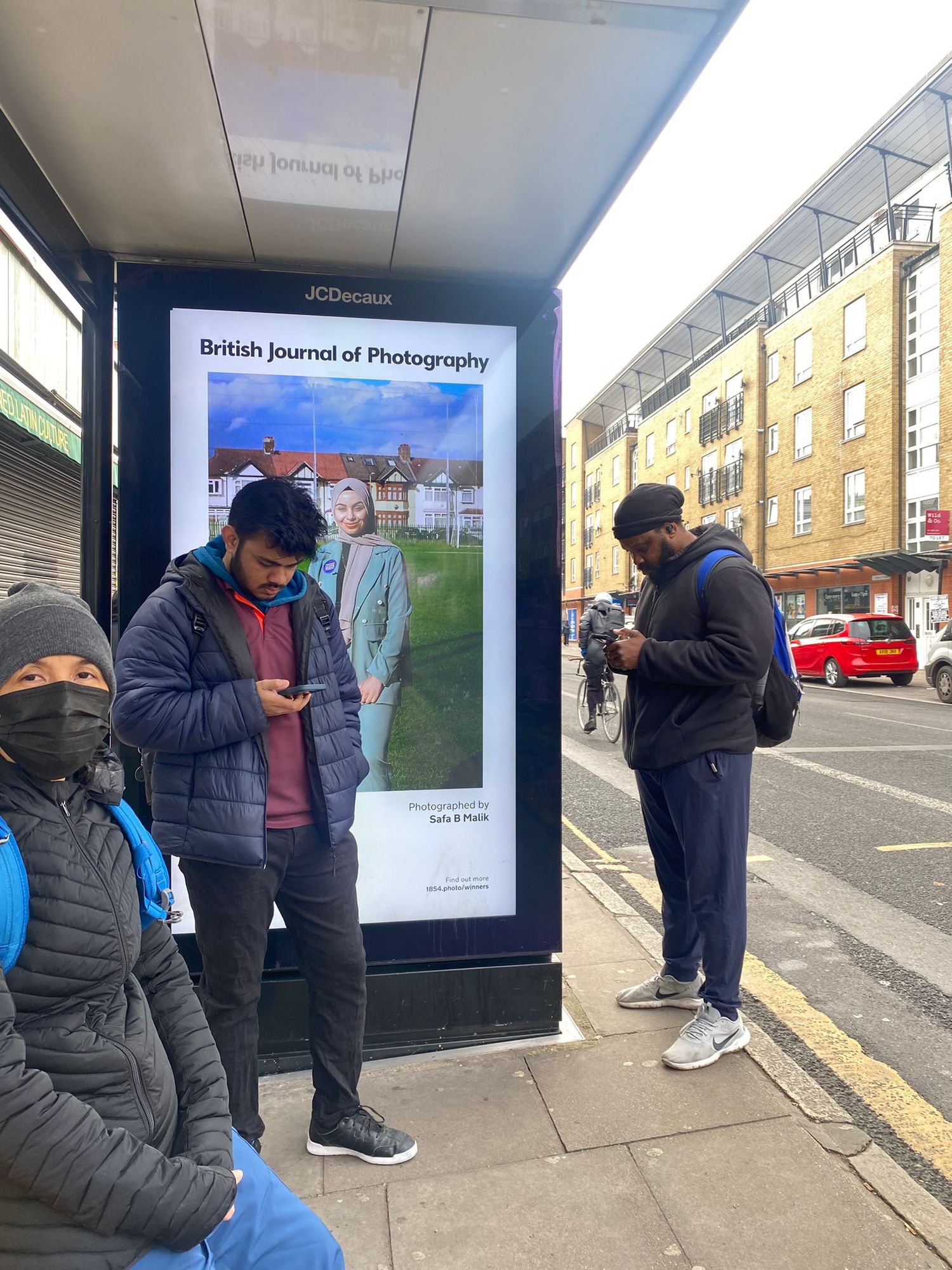 People viewing outdoor digital advertising displays on a city street.