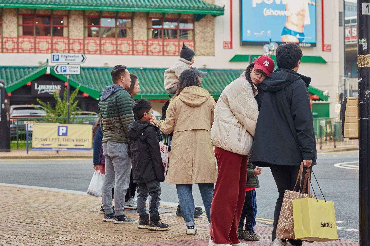 Small group of shoppers gathered outside a storefront on a winter day.