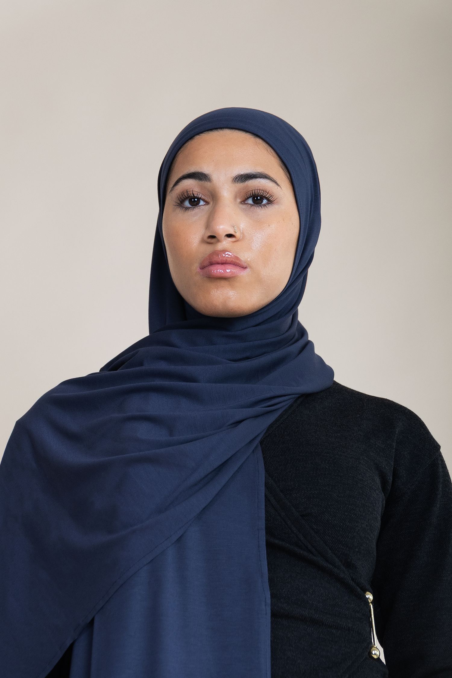 A series of profile views showing a navy blue hijab styled with a black top against a light background.