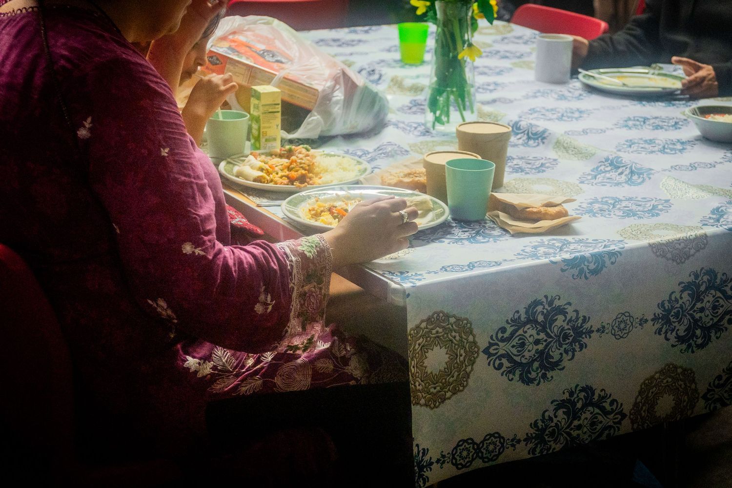 Dining table setting with blue patterned tablecloth and place settings.