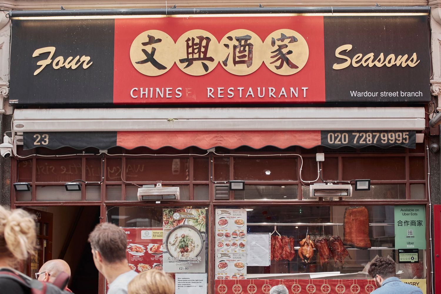 Four Seasons Chinese Restaurant storefront with red signage displaying Chinese characters in London's Chinatown.
