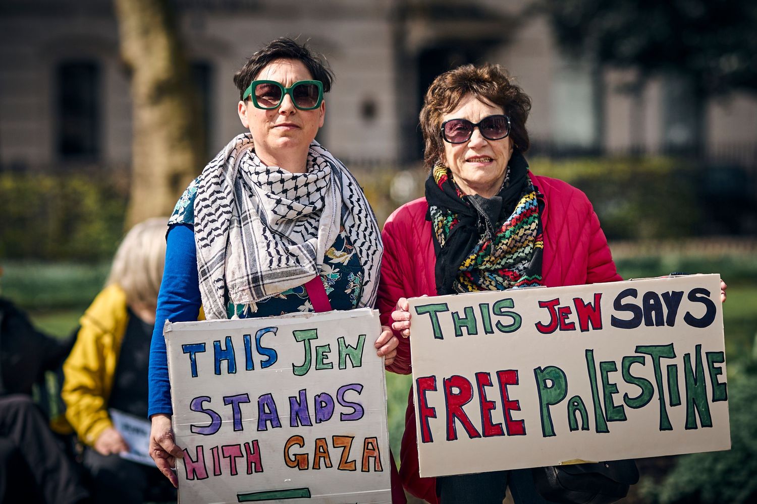 Two protesters display signs supporting Gaza and Palestine at outdoor demonstration.