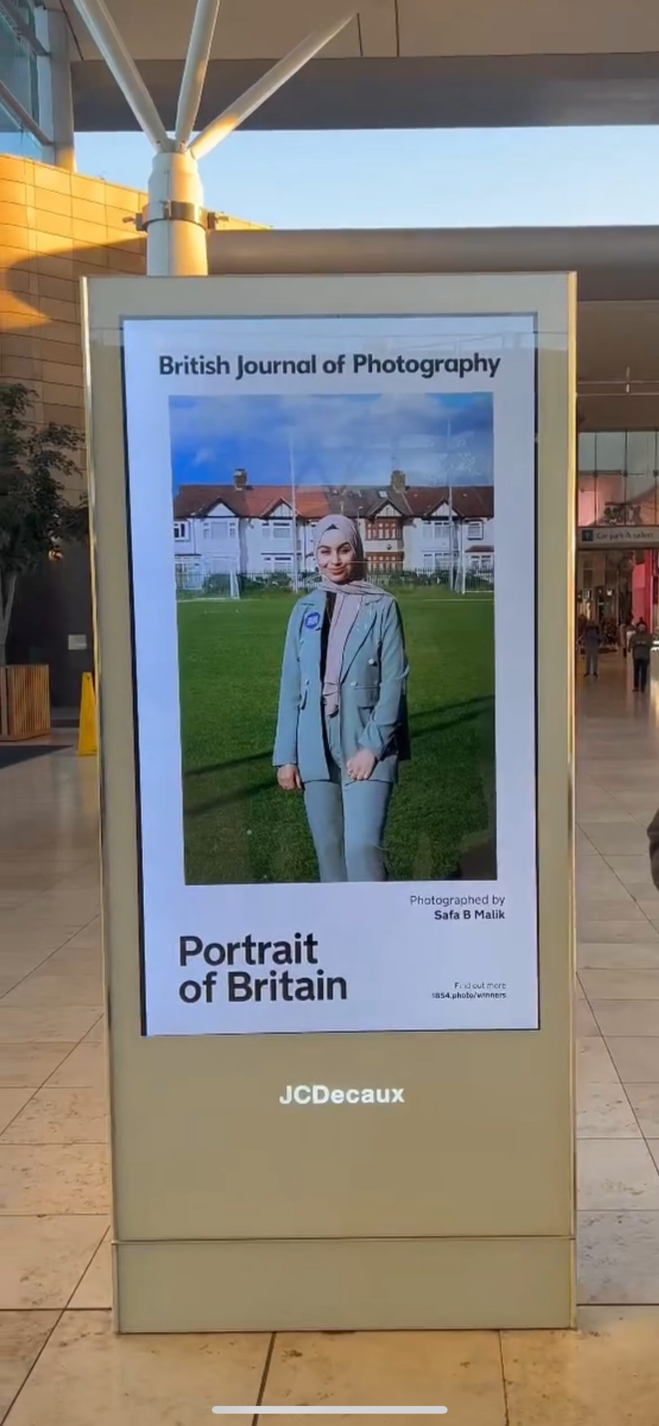 Portrait of Britain exhibition displayed on JCDecaux digital screens in an indoor mall setting.